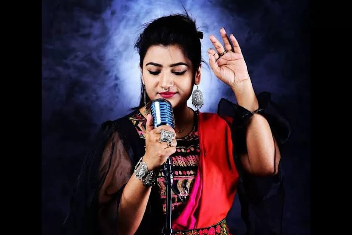 Arpita in the studio, eyes closed, singing into a vintage ribbon microphone through low smoke